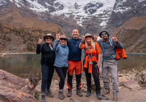 Trekking group at Humantay Lake below snowy peaks