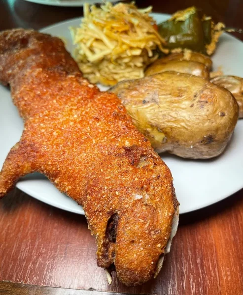 Plate of Cuy Chactado (fried guinea pig) served with potatoes and corn