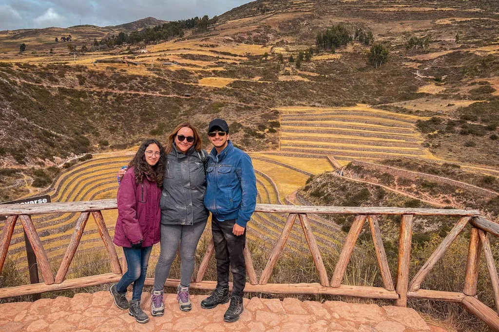 Travelers posing at the Moray circular terraces viewpoint during the ATV Maras Moray Tour in Peru